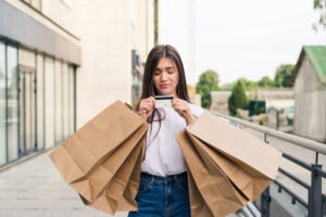 Chica con mus bolsas de compra que acaba de detectar gastos innecesarios